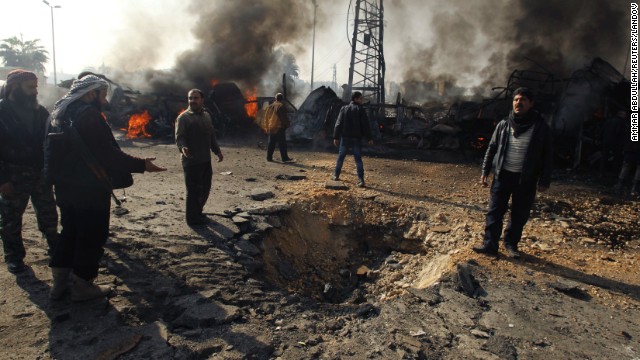 Rebels and civilians check out a crater that activists say resulted from a Syrian government airstrike on an Aleppo bus station on Tuesday, January 21.