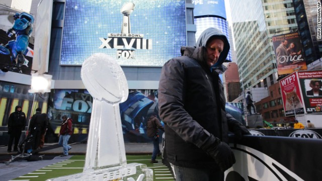 A worker in Times Square moves a barrier January 28 near an ice sculpture that is modeled after the Lombardi Trophy.