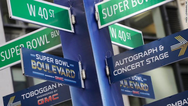 Street signs point to Super Bowl attractions in Times Square. Several blocks of Manhattan have been converted into a temporary festival space.