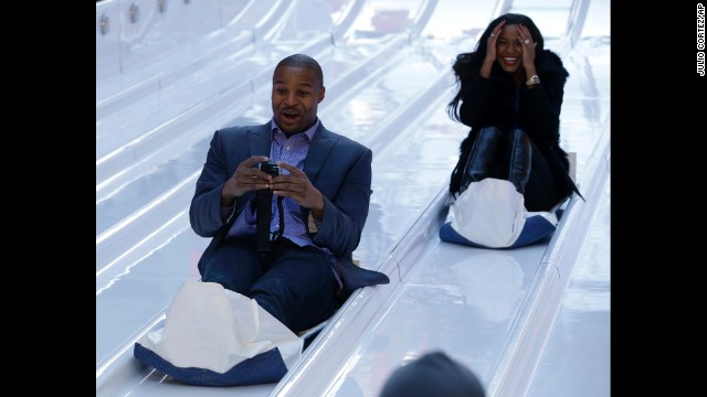 Atlanta Falcons defensive end Osi Umenyiora and his fiancee, Leila Lopes, slide down toboggans January 29 at Super Bowl Boulevard.