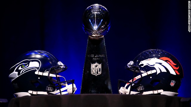 The Vince Lombardi Trophy is flanked by the helmets of the Seattle Seahawks and the Denver Broncos before the head coaches' news conference Friday, January 31, in New York City. The Broncos and the Seahawks will play for the trophy Sunday at Super Bowl XLVIII.