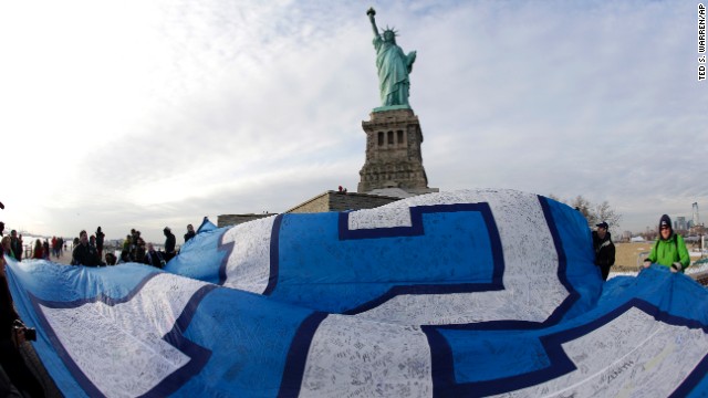 A giant Seahawks "12th Man" flag that flew on the Space Needle in Seattle before being signed by fans and brought to New York, is displayed at the Statue of Liberty on January 31. Sunday's game will be held in East Rutherford, New Jersey, just outside of New York City.