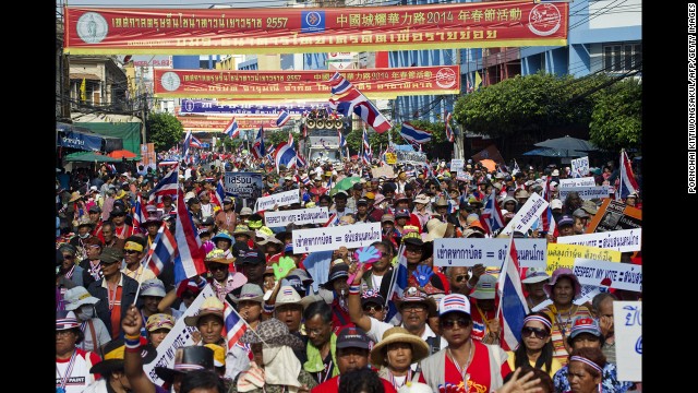 Anti-government protesters wave national flags during a parade in Bangkok.