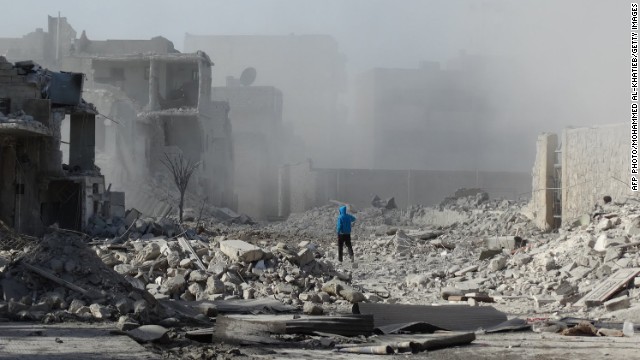 A man walks amid debris and dust on January 31.