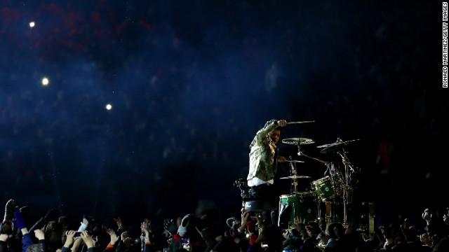 Fans surround Mars as he performs a drum solo to start the show.