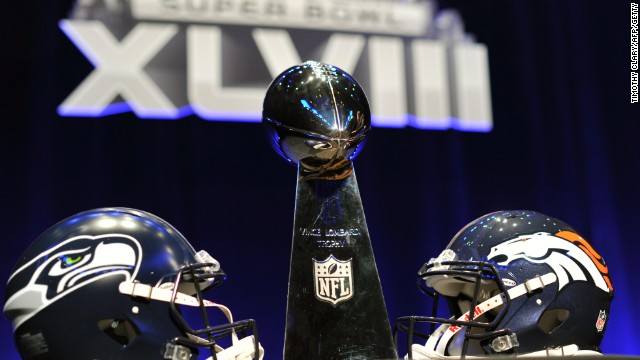 The helmets of the competing Super Bowl teams Seattle and Denver flank the iconic Vince Lombardi trophy.