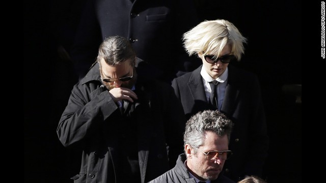 Actor Joaquin Phoenix, left, exits the church. Phoenix appeared with Hoffman in "The Master."