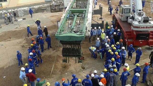 Workers surround the crane from which the piece of iron fell during its dismantling, fatally injuring the 55-year-old worker.