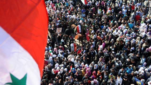 In this handout photo released by the official Syrian Arab News Agency on February 8, civilians wave national flags in Damascus as they take part in a rally in support of President al-Assad.