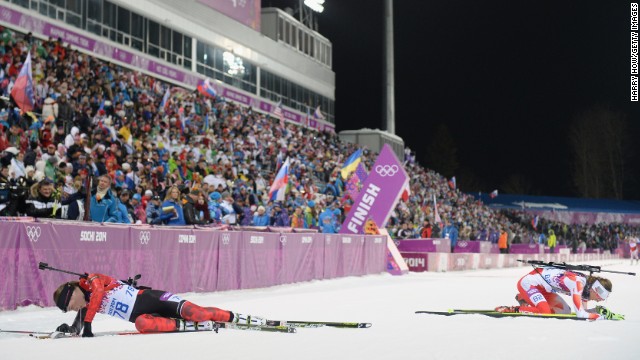 Canada's Megan Heinicke, left, and Poland's Monika Hojnisz collapse in the snow after competing in the 7.5-kilometer biathlon sprint on February 9. 