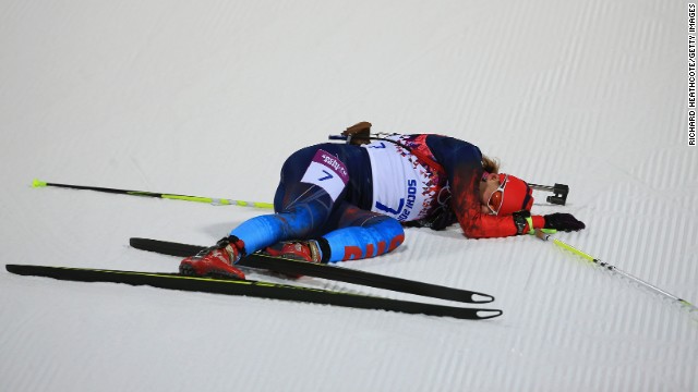 Biathlete Ekaterina Shumilova of Russia collapses on the snow February 9 after crossing the finish line in the women's 7.5-kilometer sprint. 