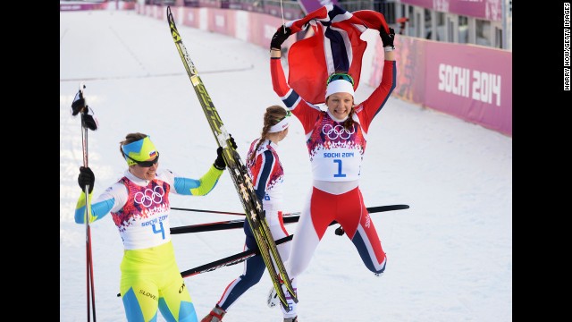 Maiken Caspersen Falla of Norway, right, and Vesna Fabjan of Slovenia celebrate February 11 after finishing in first and third place in the women's cross-country sprint.