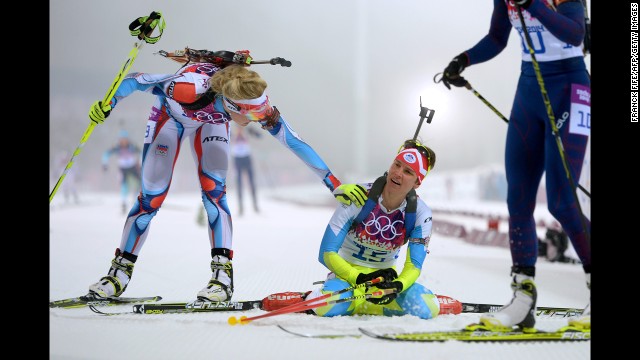 Slovenian biathlete Teja Gregorin, center, collapses at the finish line of the women's 10-kilometer pursuit on February 11.