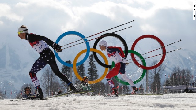 Andrew Newell of the United States leads Norway's Eirik Brandsdal as they ski past the Olympic rings during the men's cross-country sprint on Tuesday, February 11.