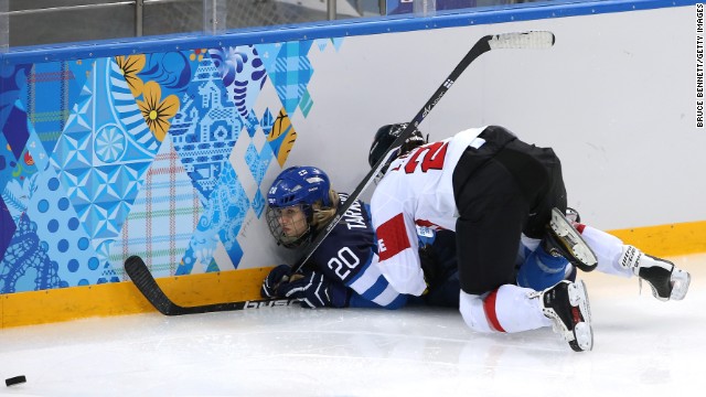 Laura Benz of Switzerland checks Saija Tarkki of Finland into the boards during a women's hockey game on February 12.