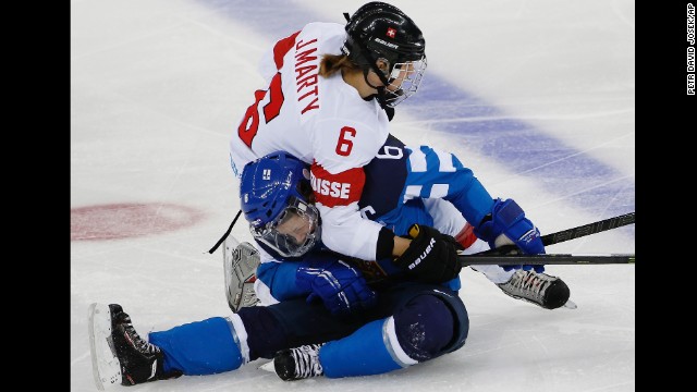 Julia Marty of Switzerland and Jenni Hiirikoski of Finland collide during the second period of their women's hockey game February 12.