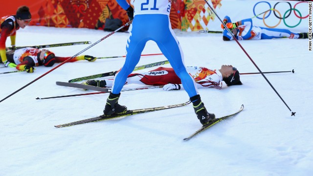 Skiers fall to the ground after the cross-country portion of the men's Nordic combined event February 12.