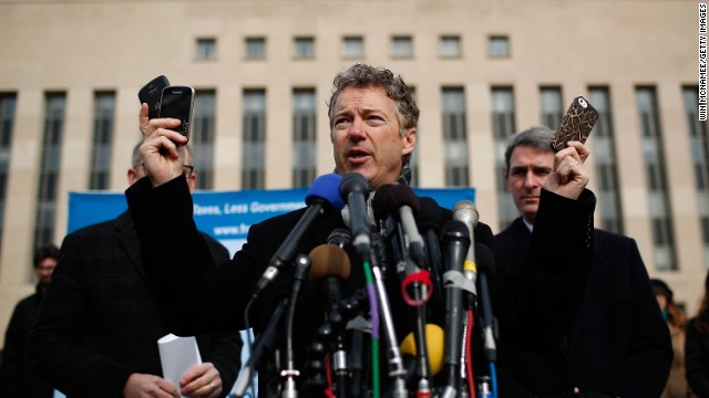 Sen. Rand Paul holds cell phones in front of federal court in Washington to announce a class-action lawsuit against the Obama administration over NSA surveillence.