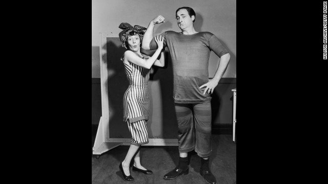 Imogene Coca feels Caesar's biceps as he mockingly flexes circa 1955. They are both dressed in period bathing suits.