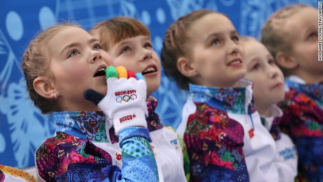 Flower girls watch the pairs figure skating competition on February 12.