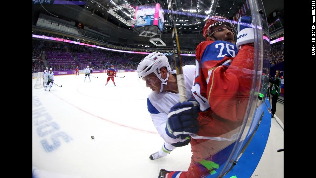 Andrej Tavzelj of Slovenia checks Vyacheslav Voynov of Russia into the glass during the men's hockey game on February 13.