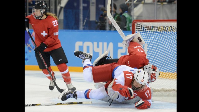 Russian forward Yekaterina Smolentseva tumbles over Swiss goalie Florence Schelling during the women's hockey game on February 15. 