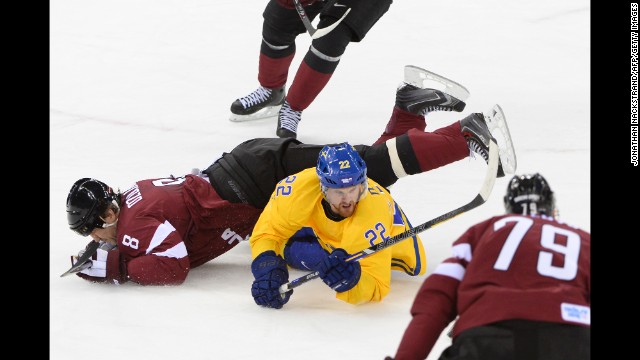 Swedish hockey player Daniel Sedin, in yellow, vies with Latvia's Sandis Ozolinsh on February 15.