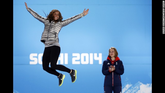 U.S. silver medalist Noelle Pikus-Pace jumps in the air as Great Britain's gold medalist Elizabeth Yarnold looks on during the women's skeleton medal ceremony on Saturday, February 15.