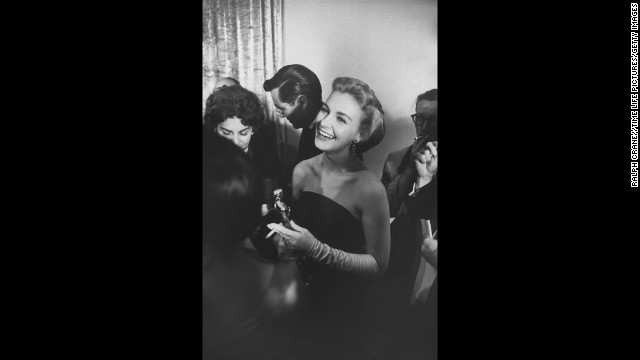 Joanne Woodward smiles while holding her best actress Oscar (and a cigarette). She received the award for her role in the film "Three Faces of Eve."