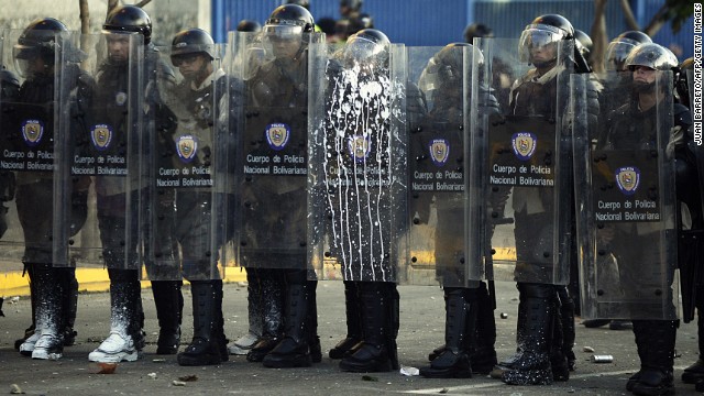 Riot police stand during clashes in Caracas on February 15.