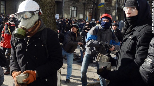 Protesters throw stones toward riot police in Kiev on February 18.