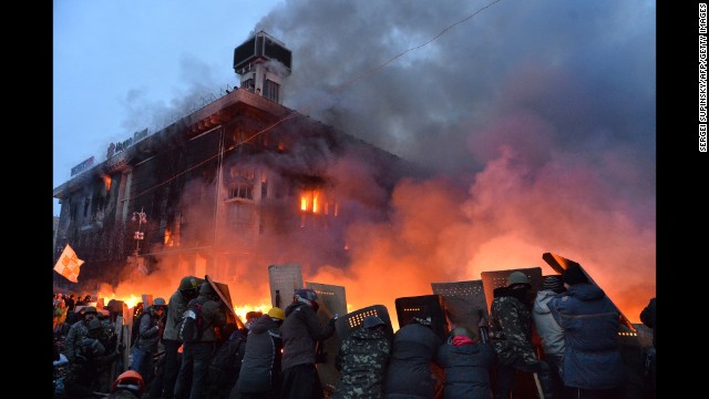 Protesters protect themselves with shields as they clash with police in Kiev on February 19.