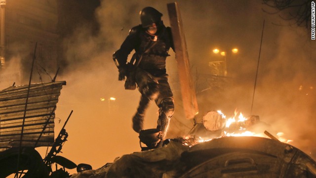 A protester runs during clashes with police in Kiev on February 18.