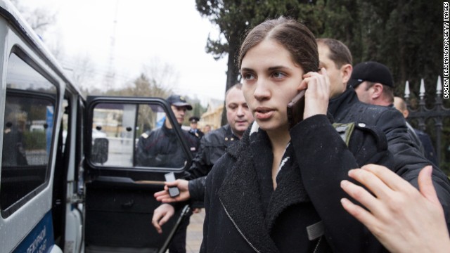 Tolokonnikova speaks on her cell phone as she is escorted to a police car on February 18. 