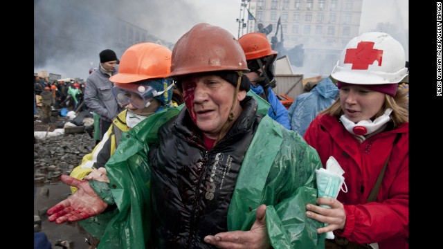 An injured protester is moved out during clashes with riot police in Kiev on February 19.