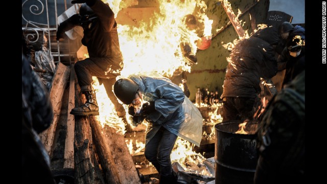 Protesters run from a burning barricade in Kiev on February 20.