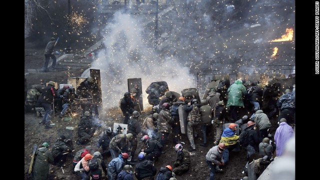 Fireworks explode over protesters near Independence Square on February 20.