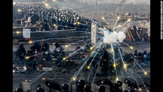 Police take cover behind shields as fireworks go off in Kiev on February 19.