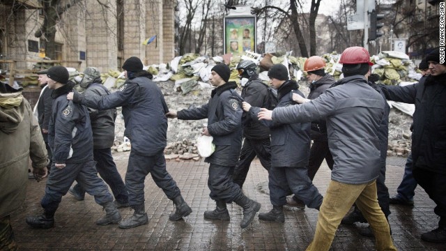 Captured police officers are led away by protesters in Kiev on February 20.