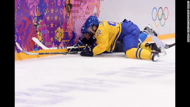 Finland's Sami Vatanen, left, vies for the puck with Sweden's Gabriel Landeskog during the men's hockey semifinal on February 21.