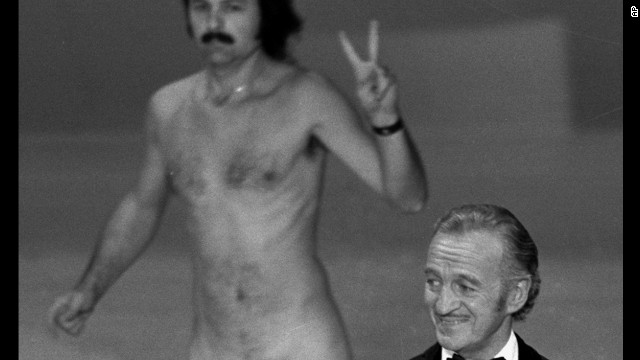 Oscar presenter David Niven isn't quite sure what's happening behind him as a streaker crosses the stage near the end of the 1974 Academy Awards. The streaker later identifies himself as Robert Opel. 