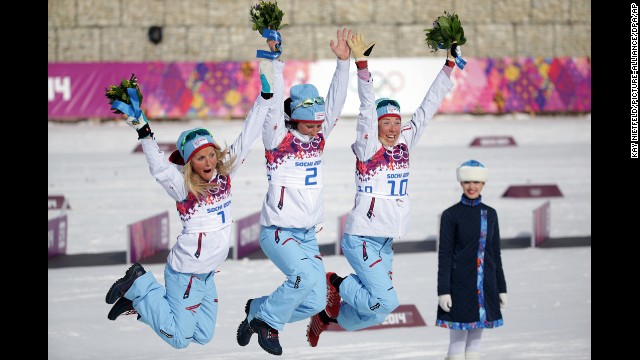 From left, second place medalist Therese Johaug, first place medalist Marit Bjoergen and third place medalist Kristin Stoermer Steira, all of Norway, celebrate during the flower ceremony for the 30-kilometer mass start free on Saturday, February 22.