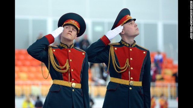 Russian honor guards salute on February 22, during the ladies' speed skating team pursuit medal ceremony.