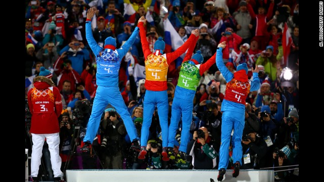 Gold medalists Anton Shipulin, Dmitry Malyshko, Evgeny Ustyugov and Alexey Volkov of Russia celebrate on the podium during the medal ceremony for the men's 4x7.5-kilometer relay.