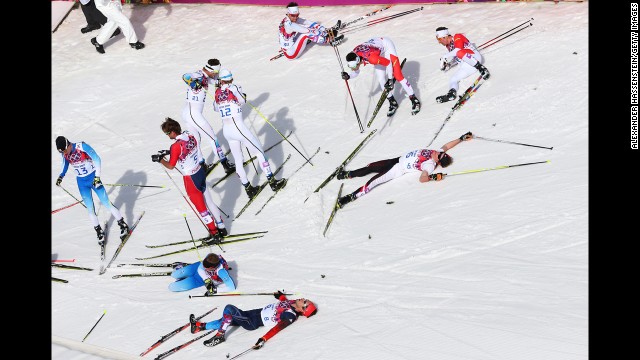 Skiers collapse on the snow after the men's 50-kilometer mass start free on February 23.