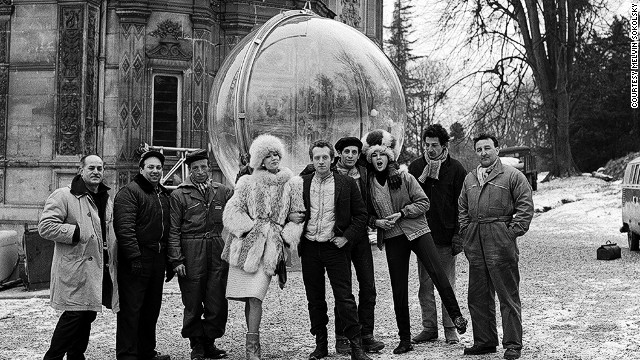 Here photographer Melvin Sokolsky, model Simone D'Aillencourt, and crew pose beside the bubble in Paris.