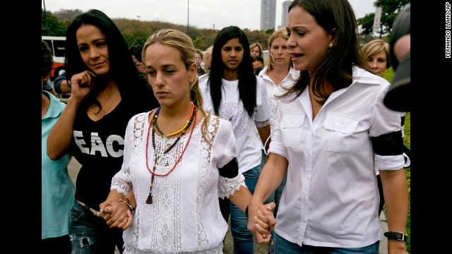 Lilian Tintori de Lopez, the wife of jailed opposition leader Leopoldo Lopez, center, walks hand in hand with actress Norkys Batista, left, and lawmaker Maria Corina Machado as they arrive for a news conference in Caracas on February 24.