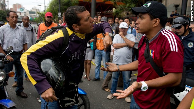 A motorcyclist, left, argues with demonstrators blocking a highway in Caracas on February 24.
