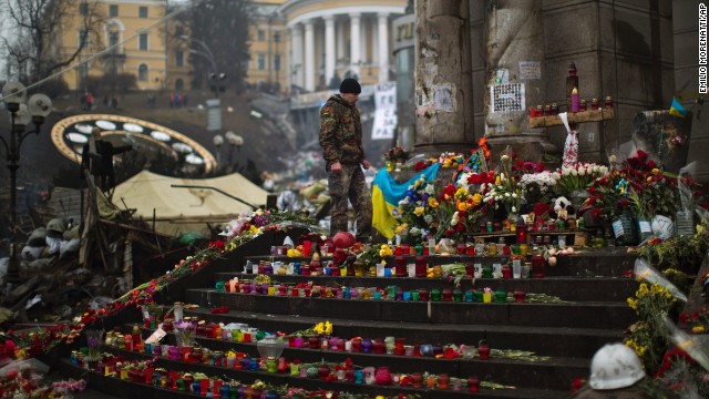 A protester stands at a memorial March 1 for the people killed in clashes at Independence Square.