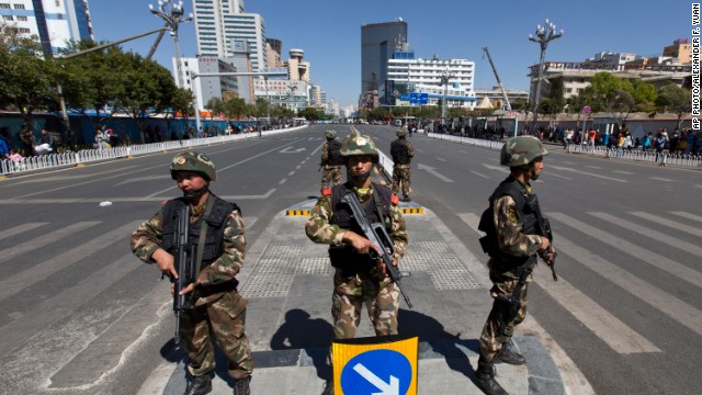 Armed paramilitary policemen guard a crossing in front of Kunming Railway Station in Kunming after a Saturday attack that left dozens dead. 